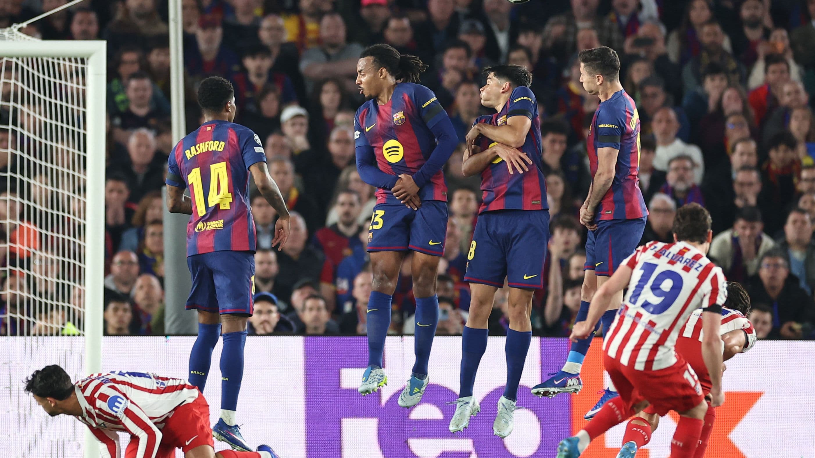 Football players challenging for the ball under stadium lights